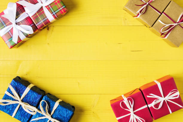 istock Gift boxes over yellow wooden background with copy space 884167106