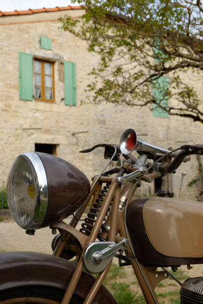 istock Old brown motorcycle in front of old stoned house 884171598