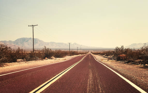 istock Retro old filmy stylized picture of an empty road. 884172612