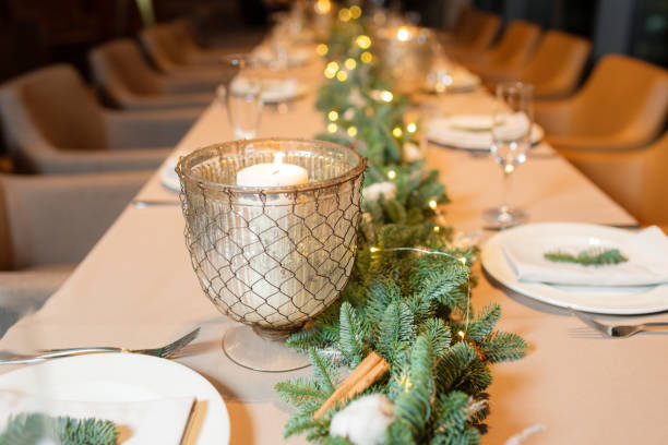 istock Christmas dinner feast. A decorated dining table with champagne glasses and christmas tree in background 884179086