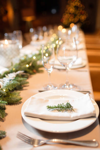 istock Christmas dinner feast. A decorated dining table with champagne glasses and christmas tree in background 884183620