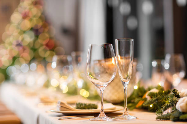 istock Christmas dinner feast. A decorated dining table with champagne glasses and christmas tree in background 884184086