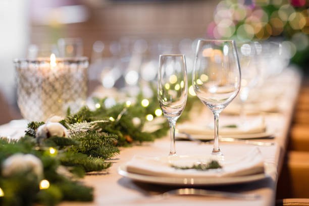 istock Christmas dinner feast. A decorated dining table with champagne glasses and christmas tree in background 884184892