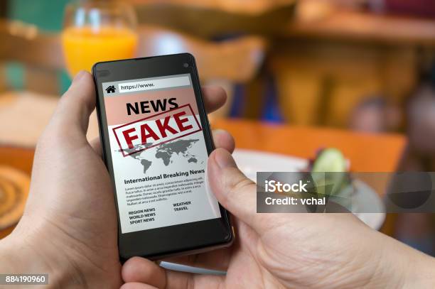 Luomo Tiene Lo Smartphone E Legge Fake News Su Internet Propaganda Disinformazione E Concetto Di Bufala - Fotografie stock e altre immagini di Mass Media