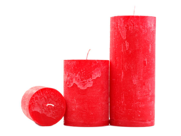istock Three red wax candles of different size isolated on white background 884197298