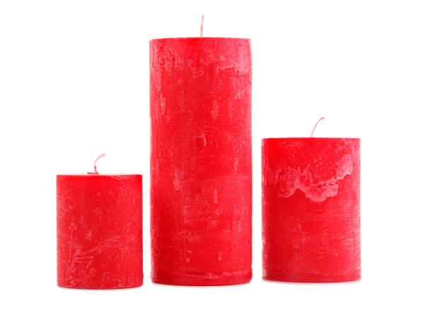 istock Three red wax candles of different size isolated on white background 884197438