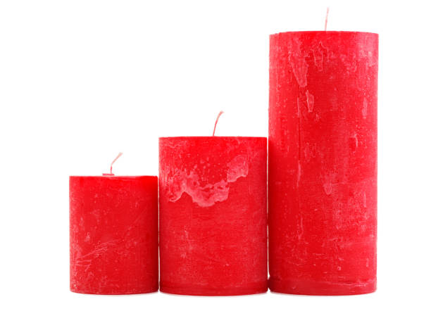 istock Three red wax candles of different size isolated on white background 884198126