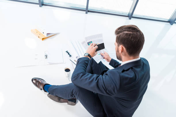 istock businessman with smartphone and papers 884203220