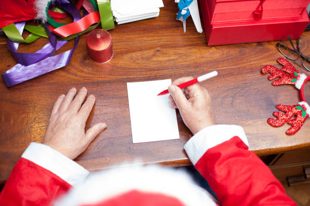 istock Father christmas writing letters at his home 884217744