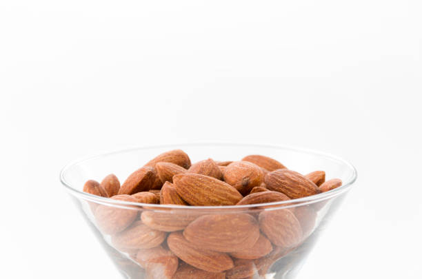 istock group of almonds in Glass container isolated white background 884220822