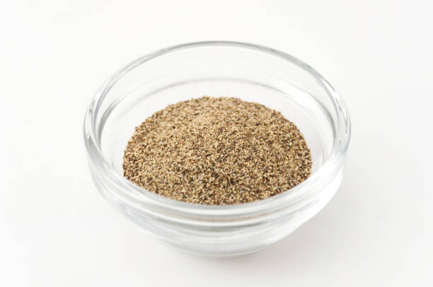 istock Ground black pepper in Glass container isolated on white background 884221034