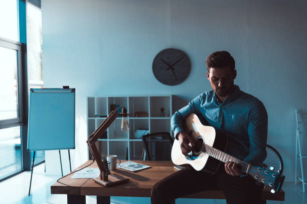 istock businessman with guitar in office 884225332