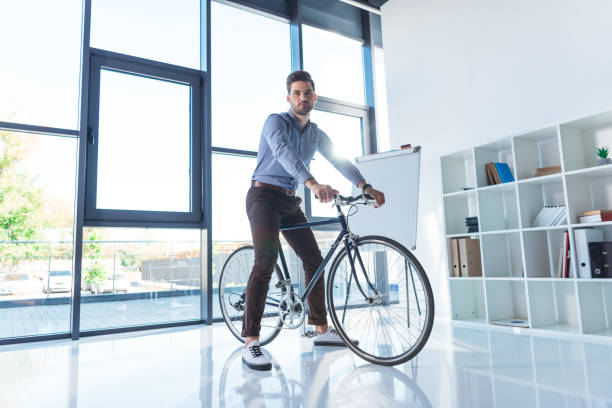 istock businessman with bicycle in office 884227718