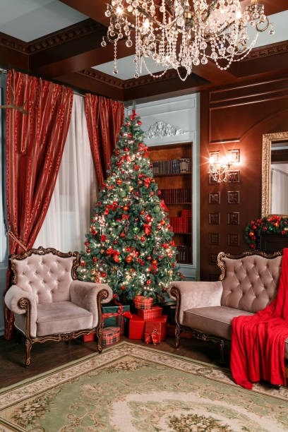 istock Christmas evening. classic apartments with a white fireplace, decorated tree, sofa, large windows and chandelier. 884240686