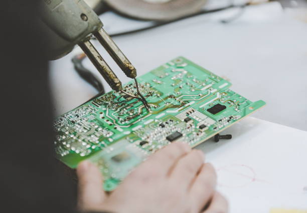 istock Man Repairing Electronic Circuitr using welder tool 884243710