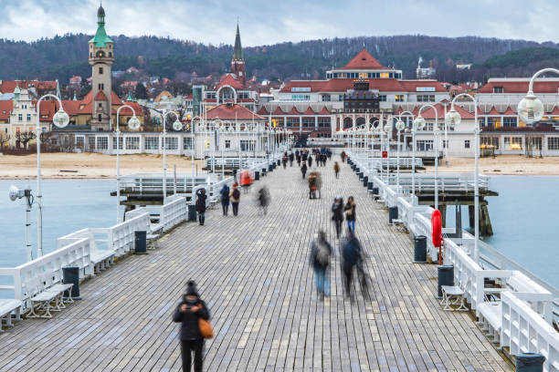 Sopot Pier (Molo) in the city of Sopot, Poland People walking on a pier (Molo) in Sopot city, Poland. Built in 1827 with 511m long it is the longest wooden pier in Europe (Long exposure, non recognizable people) baltic sea people stock pictures, royalty-free photos & images