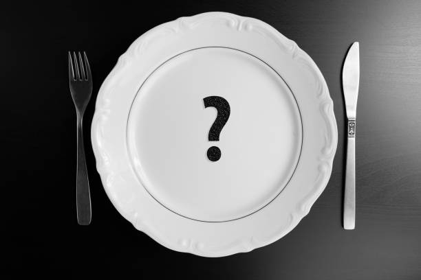 istock What to eat concept. Top view empty white plate on black background with question mark. 884246160