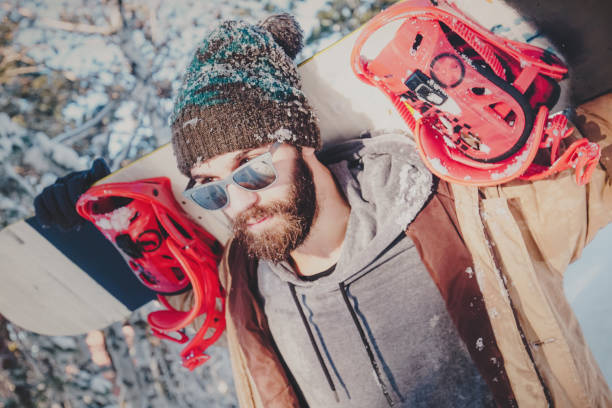 istock Hipster man with snowboard on mountain 884276508