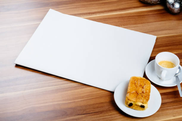 istock Empty newspaper, espresso and chocolate croissant on a wooden table 884321042