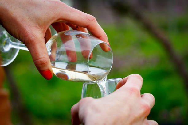 istock White wine is poured from one wine glass into another 884330586