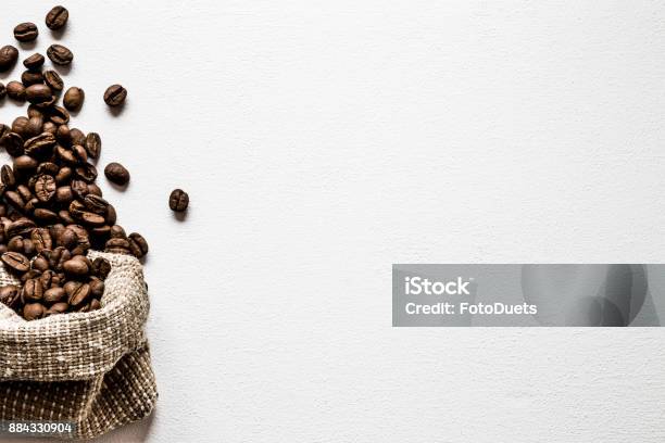 Brown Beans With Burlap Bag On The White Table Harvest Of Coffee In Different Countries Choice Of The Best Sort And Quality Coffee Empty Place For A Text Web Background Stock Photo - Download Image Now