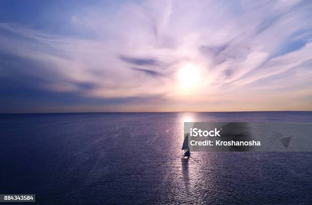 Romantic Frame Yacht Floating Away Into The Distance Towards The Horizon In The Rays Of The Setting Sun Purplepink Sunset Stock Photo - Download Image Now