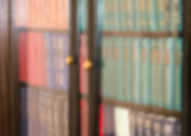 istock Books behind glass in a bookcase. Blurred horizontal background. 884347186