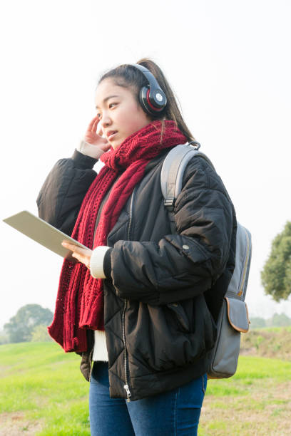 istock young female carrying digital tablet walking in park 884356124
