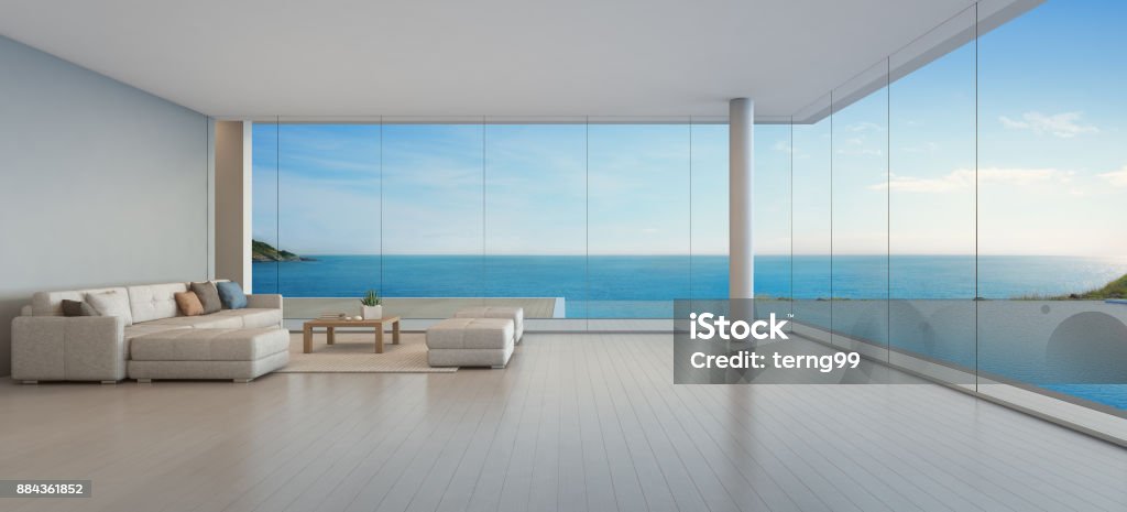Large sofa on wooden floor near glass window and swimming pool with terrace at penthouse apartment, Lounge in sea view living room of modern luxury beach house or hotel 3d rendering of interior with table and sofa Sea Stock Photo