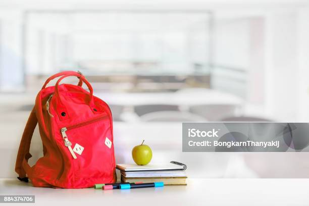 Red Backpack And Books School Supplies In Classroom Stock Photo - Download Image Now