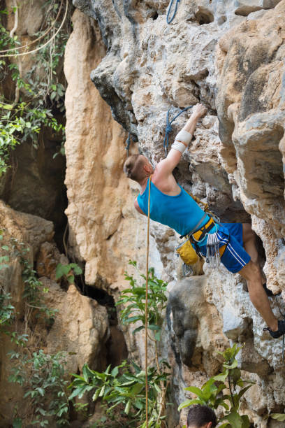 istock Young man rock climbing on white mountain 884381460