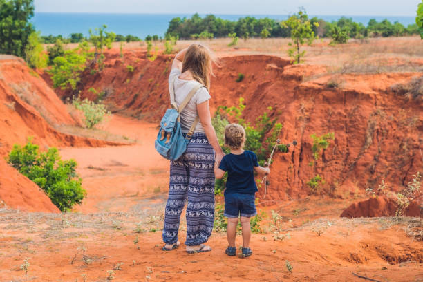 Mother and son travelers in red canyon near Mui Ne, southern Vietnam. Traveling with children concept Mother and son travelers in red canyon near Mui Ne, southern Vietnam. Traveling with children concept. mui ne bay photos stock pictures, royalty-free photos & images