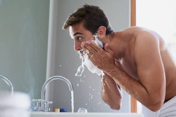 Start your day with a splash Cropped shot of a handsome young man in his bathroom shaving stock pictures, royalty-free photos & images