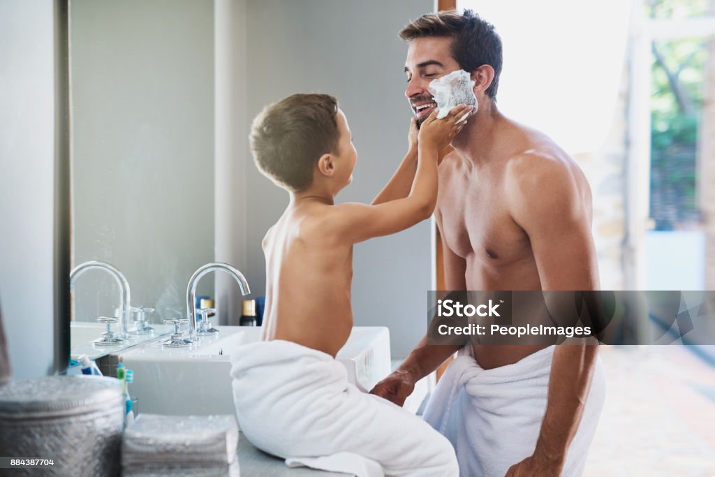 I'll put it on for you! Cropped shot of a handsome young man teaching his son how to shave in the bathroom Father Stock Photo