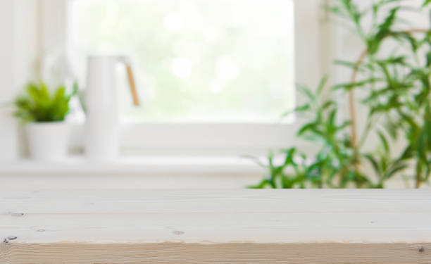 istock Wooden tabletop with copy space over blurred kitchen window background 884388532