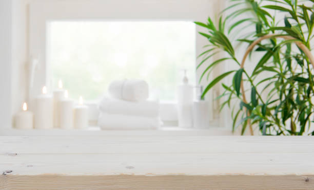 istock Wooden tabletop with copy space over blurred spa window background 884388614