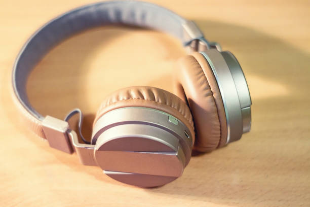 istock Bluetooth headphone on wooden background 884431742