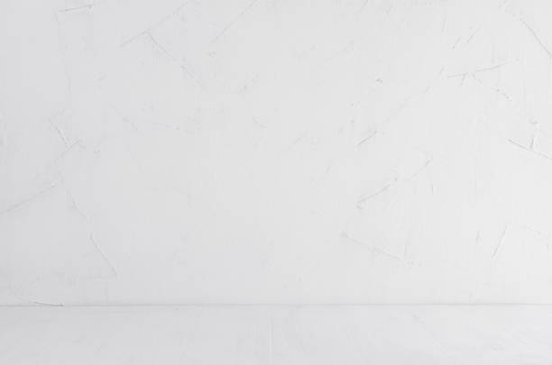 istock White shabby plaster wall and white wood board. Empty shelf, interior. 884437988