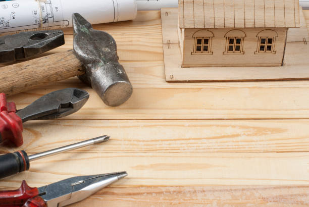 istock Construction concept. Model house,drawing and work tools on wooden background . Copy space for text. 884440536