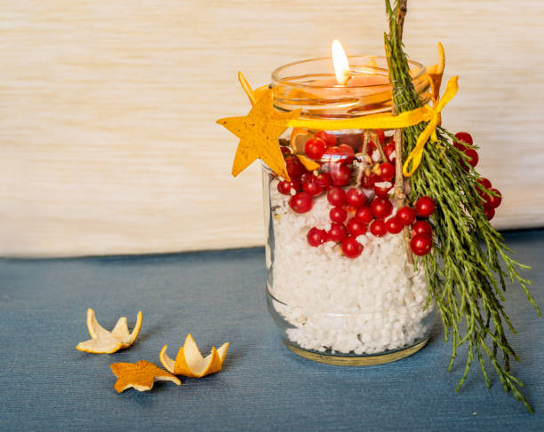istock christmas hand made candle with red berries craft on the blue tablecloth 884445178