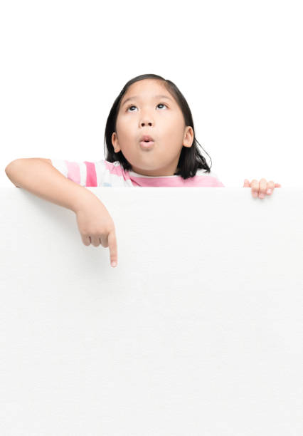 istock cute asian girl pointing on white banner board 884462662