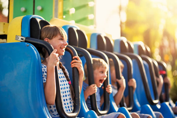 Kids having extreme fun in amusement park drop tower Kids being dropped down in a small drop tower in amusement park. Kids are laughing and shouting on a sunny summer day. amusement park photos stock pictures, royalty-free photos & images