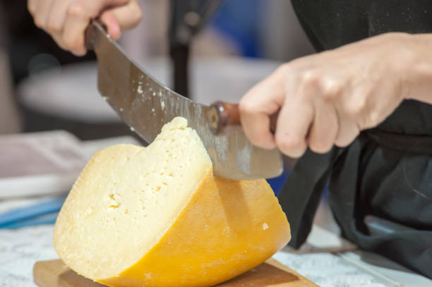 Cutting hard cheese in grocery shop