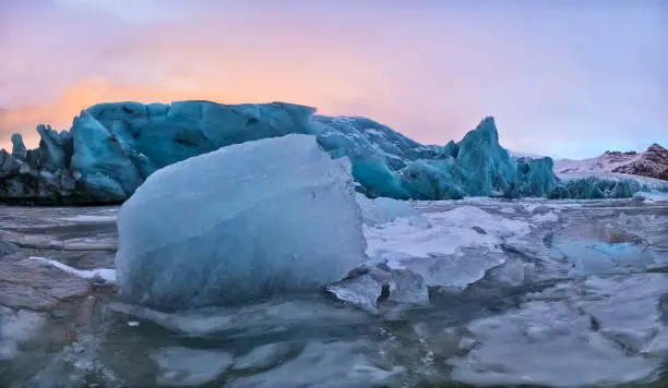 Iceberg lagoon in Fjallsarlon, Iceland. Panoramic view of beautiful sunset light, concept of global warming and ice melting.