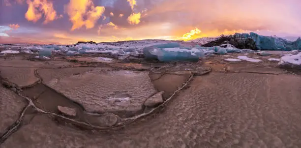 Iceberg lagoon in Fjallsarlon, Iceland. Panoramic view of beautiful sunset light, concept of global warming and ice melting.