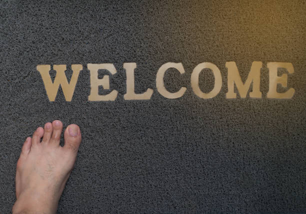 istock foot stand on grey welcome mat on floor 884486738