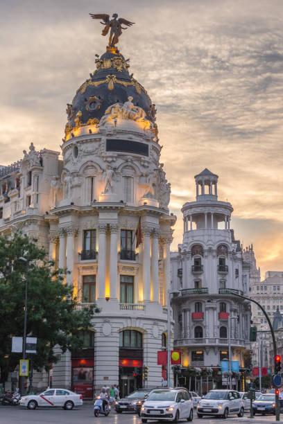 madrid da baixa, no gran via principal rua comercial com semáforo durante o pôr do sol do crepúsculo, espanha. - metropolis building - fotografias e filmes do acervo