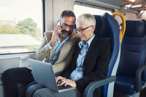 istock Business people in train traveling 884495840