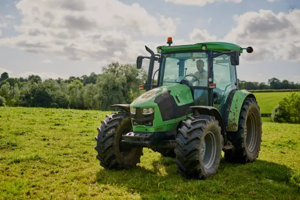 Full length shot of a green tractor on an open piece of farmland