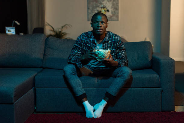 istock african american man watching tv 884502582